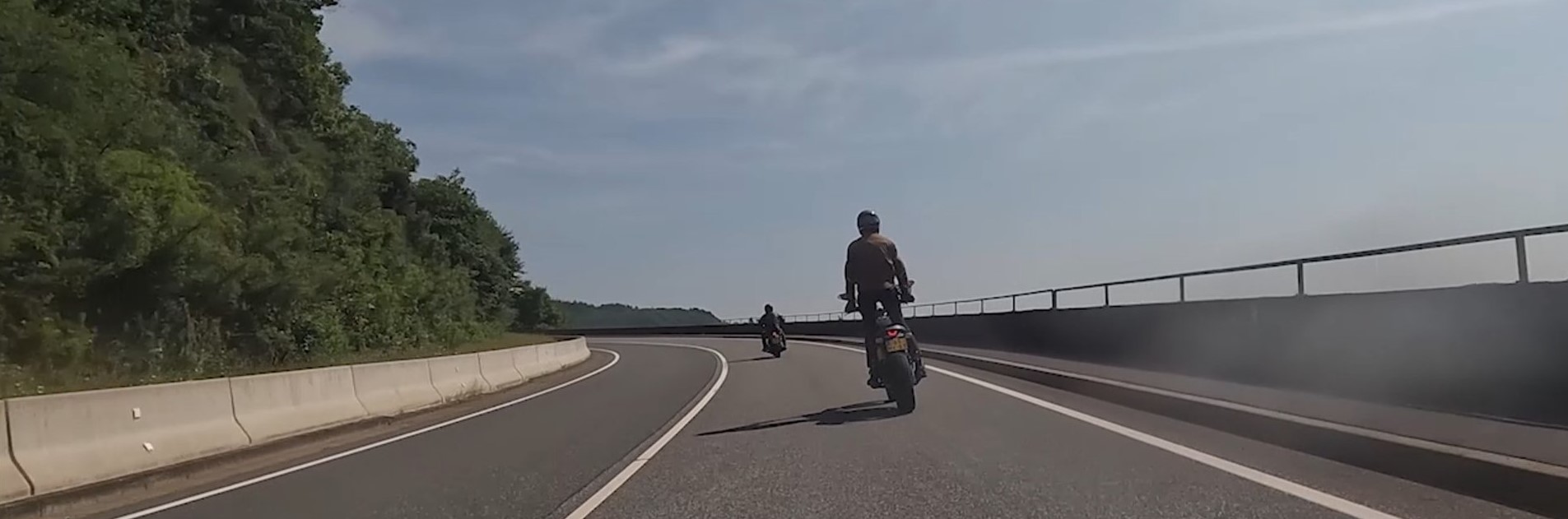 Twee motoren nemen een bocht op een tweebaansweg
